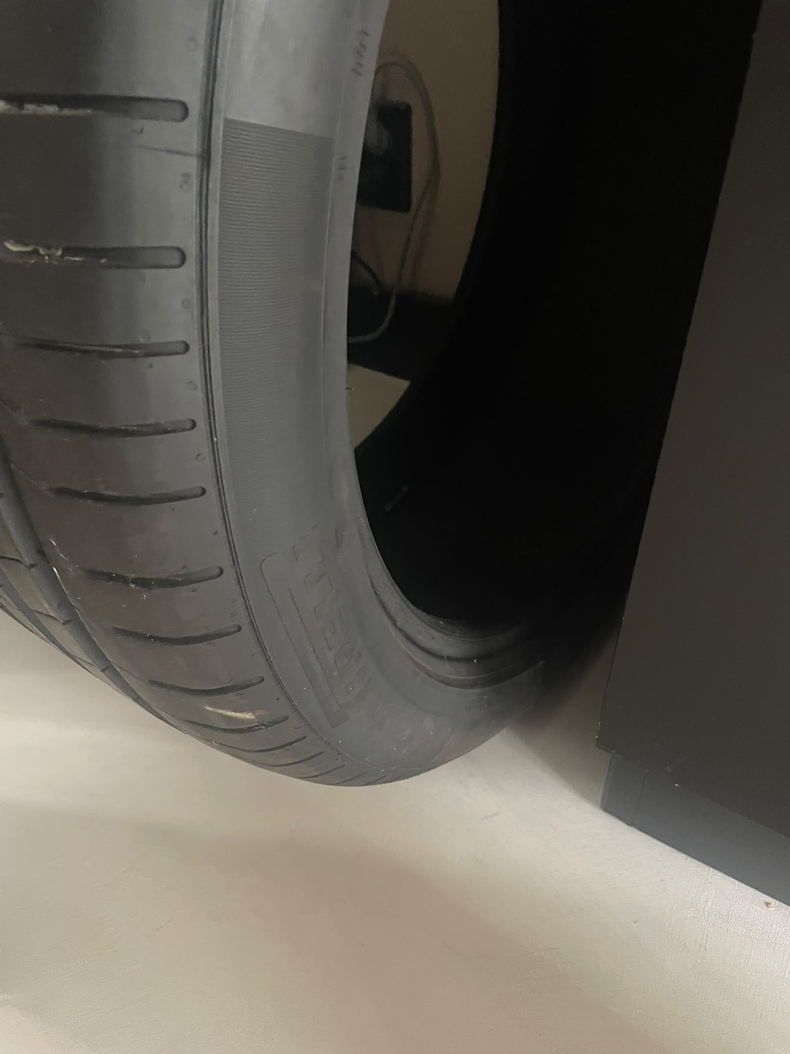 Test met autoband op witte lavasteen gietvloer, kleur linnen &mdash; zichtbare bandensporen