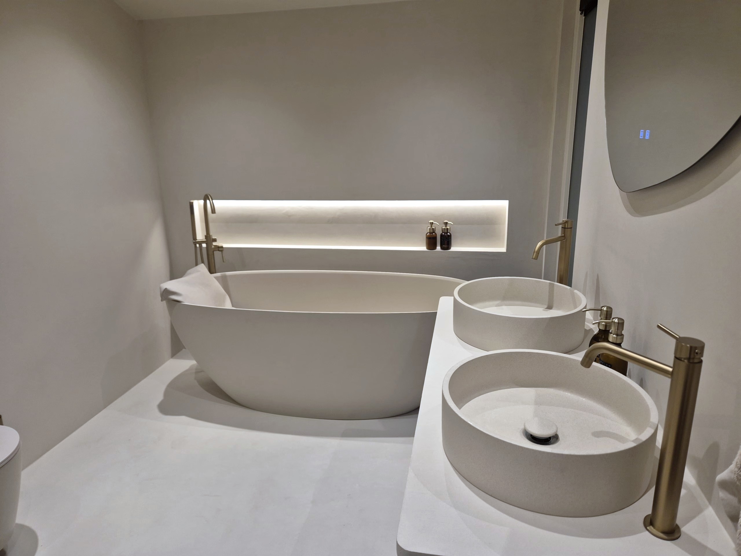 Badkamer in Cream Peony met een lavasteen gietvloer en een vrijstaand bad